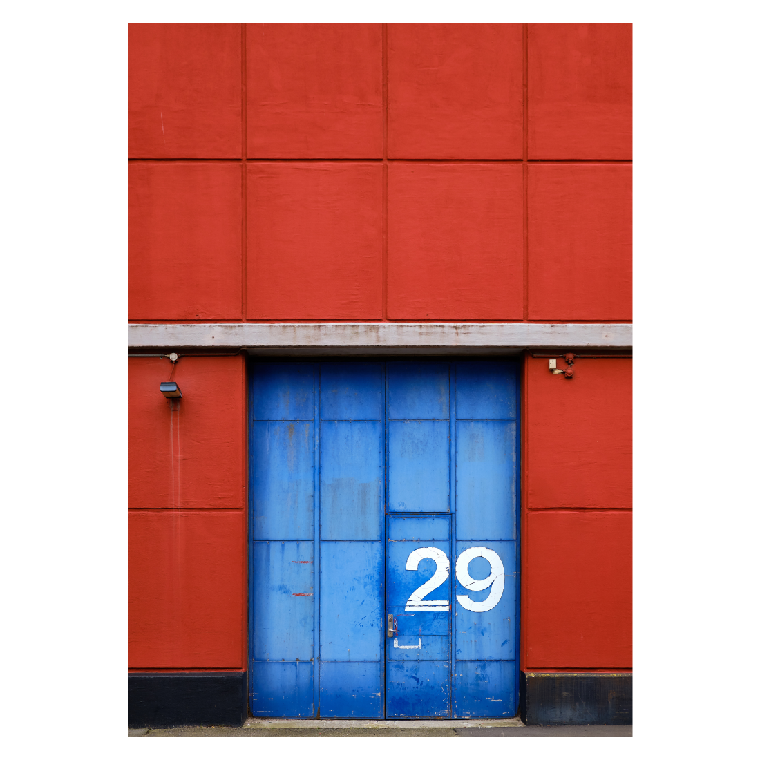 plakat med blå port i en rød mur