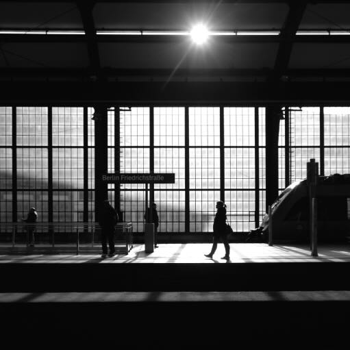 Silhouette af mennesker og tog på Friedrichsstrasse station i Berlin