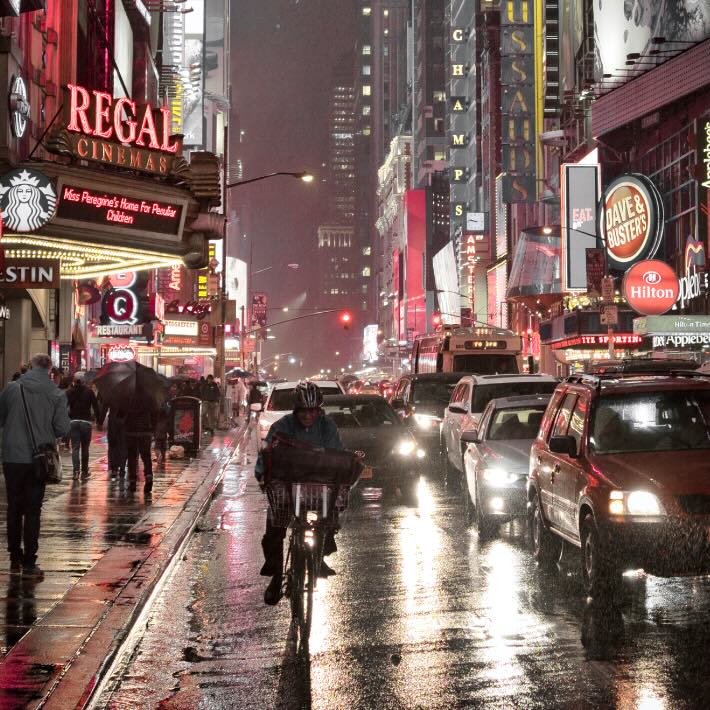 Udsnit af et billede med cyklist i pis øs regnvejr i New Yorks gader